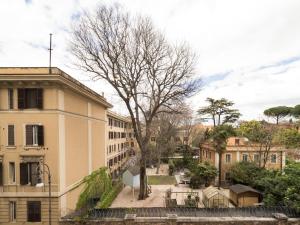 a street in a city with buildings and a tree at Savoia Rooms Roma in Rome