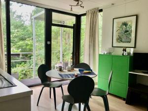 een eetkamer met een tafel en stoelen en een raam bij Linden-Jachthoorn in Lubbeek