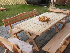 a wooden picnic table with a basket of fruit on it at Ferienhaus Wiesenchalet im Sauerland in Schalksmühle
