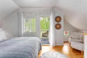 a bedroom with a bed and a chair and a window at Villa Kesätie - Lakeside Paradise in Nurmijärvi