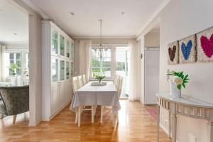 a dining room with a white table and chairs at Villa Kesätie - Lakeside Paradise in Nurmijärvi
