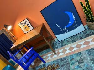 a wooden table and a blue chair next to a wall at Medusa Home Stay in Amman