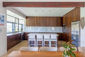 eine Küche mit Holzschränken und weißen Hockern in der Unterkunft Marribrae I Private Properties in Yallingup + 19 Fotos