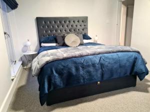 a bedroom with a bed with a blue comforter at Art Deco Beauty on The Bay Hill in Timaru
