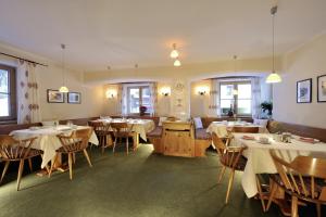 una sala da pranzo con tavoli e sedie bianchi di Hotel Garni Albona a Sankt Anton am Arlberg