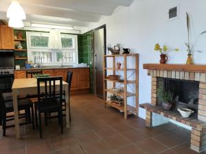 a kitchen with a table and a fireplace at Casa Flor de Taronger in Viladecáns