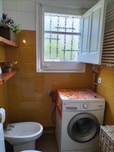 a bathroom with a washing machine and a window at Casa Flor de Taronger in Viladecáns