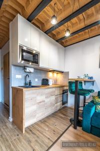 a kitchen with white cabinets and a table in a room at Apartamenty Yeti & Wilka w Centrum Chorzowa: Wilk in Chorzów