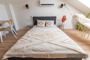 una camera da letto con un grande letto con una coperta di Apartamenty Yeti & Wilka w Centrum Chorzowa: Wilk a Chorzów