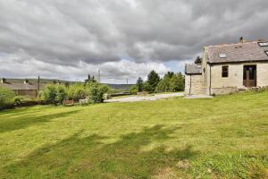 an old building in a field with a grass yard at Lanehead Old School in Lanehead