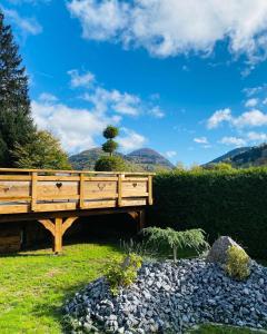 a wooden bench in a garden with mountains in the background at Chalet le Bô & Spa in Bussang