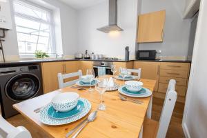 a kitchen with a wooden table with plates and dishes on it at Free Parking Leisure Contractor Central in Rishton