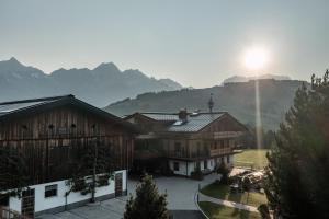 um grupo de edifícios com montanhas ao fundo em Biohof Ebengut em Maria Alm am Steinernen Meer