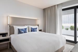 a large white bed in a hotel room with a window at Courtyard by Marriott Batumi in Batumi