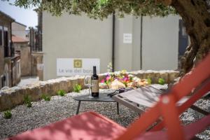 - une bouteille de vin assise sur une table sous un arbre dans l'établissement Le vie del Borgo, à Civita