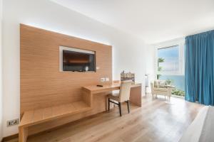 a room with a desk and a television on a wall at Kriss Internazionale Hotel in Bardolino