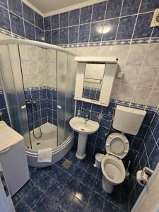 a blue tiled bathroom with a toilet and a sink at Lanterna Apartments in Kotor