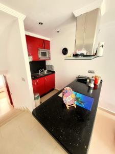eine Küche mit roten Schränken und einer schwarzen Arbeitsplatte in der Unterkunft Playa bonita in Estepona