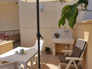 un patio con mesa, 2 sillas y sombrilla en Greenwich House, en Monopoli 15 fotos más