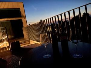 2 bicchieri da vino seduti su un tavolo sul balcone di Chalet Park by Maier Höchst a Höchst