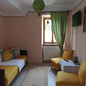 un soggiorno con mobili gialli e una finestra di Dorino Domaćinstvo a Novi Bečej