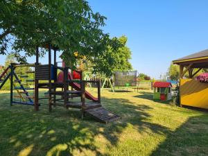 a park with a playground with a swing at Domki letniskowe Zacisze in Rusinowo