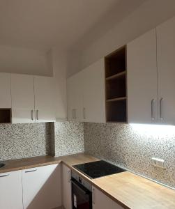 a kitchen with white cabinets and a stove top oven at M&D Apartment in Struga