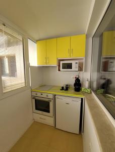 een kleine keuken met gele kasten en een magnetron bij Danaya's apartment in Varna