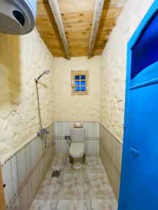 een kleine badkamer met een toilet en een raam bij خزفستا Khazfista in ‘Izbat an Nāmūs
