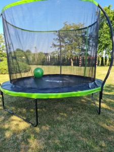 a trampoline with a green ball in a net at Domki letniskowe Zacisze in Rusinowo