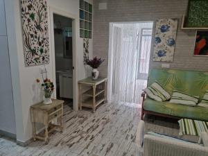 een woonkamer met een groene bank en een tafel bij PLANTA BAJA-BENICARLO in Benicarló