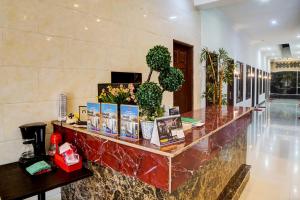 a lobby with a counter with flowers and plants at OYO 92638 Jr Residence Syariah in Medan