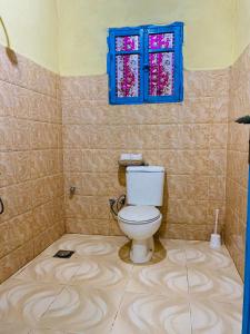 a bathroom with a toilet and a window at خزفستا Khazfista in ‘Izbat an Nāmūs