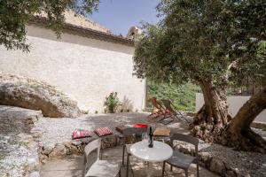 a table and chairs sitting under a tree at Le vie del Borgo in Civita