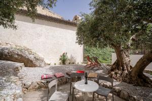 una mesa y sillas sentadas bajo un árbol en Le vie del Borgo, en Civita