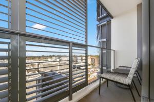 Un balcón con una silla y un escritorio. en Broad Land Premium Apartments Chatswood Sydney, en Sídney