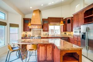 a kitchen with wooden cabinets and a large island with bar stools at Sacramento Home with Fire Pit 15 Mi to Downtown! in Sacramento