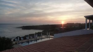 a view of the ocean from a balcony with the sunset at Villa Halcyon cabo verde in Cidade Velha