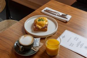 a table with a plate of doughnut and a glass of orange juice at Hotel Indigo Belgrade, an IHG Hotel in Belgrade