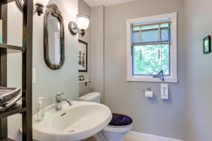 a bathroom with a sink and a toilet and a mirror at 'Locke’s Glen' - Lakefront Geneva Getaway w/ Dock! in Geneva +36 photos