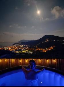 Eine Person in einer Badewanne bei Nacht mit dem Mond in der Unterkunft Casa tra Cielo e Mare in Lipari