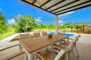 a dining room with a wooden table and chairs at Villa Laura Mia by IstriaLux in Juršići