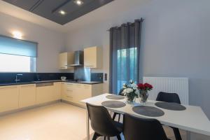 a kitchen with a white table and chairs and a kitchen with a window at Villa Moonstone in Mouzákion
