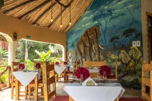 une salle à manger avec une fresque murale représentant un éléphant dans l'établissement Africa Safari Arusha, à Arusha