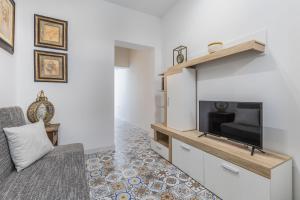 - un salon avec une télévision et un canapé dans l'établissement Town House Luqa, à Ħal Luqa