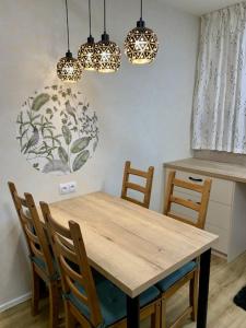 - une table et des chaises en bois dans une cuisine éclairée dans l'établissement Apartmán Šnyt Primka, à Olomouc