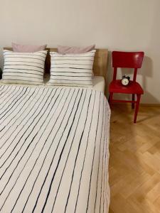 - une chambre avec un lit et une chaise rouge dans l'établissement Apartmán Šnyt Primka, à Olomouc