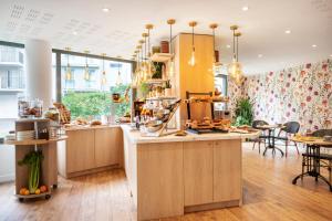 a kitchen with wooden cabinets and a counter top at Séjours & Affaires Paris-Malakoff in Malakoff