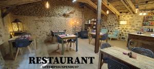 a restaurant with tables and chairs in a room at Le Temps Suspendu in Saint-Pierreville