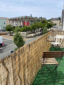 une clôture en bois avec un banc en bois et une table dans l'établissement Le logis des Halles, à Cerizay